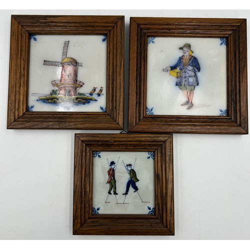 1189 - Makkum hand painted tiles depicting a picture of a windmill, stilt walkers and a sweet seller. Two M... 