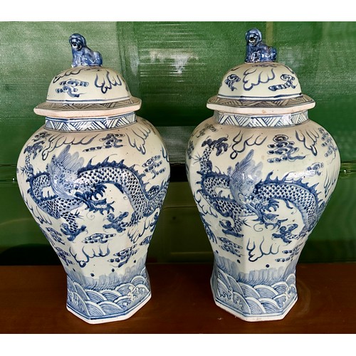 936 - A pair of large blue and white vases with covers, the bodies  decorated with dragons and flaming pea... 