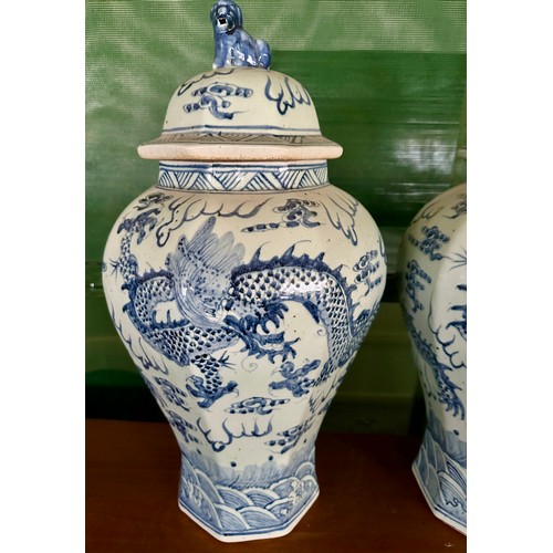 936 - A pair of large blue and white vases with covers, the bodies  decorated with dragons and flaming pea... 