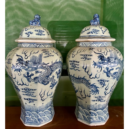 936 - A pair of large blue and white vases with covers, the bodies  decorated with dragons and flaming pea... 