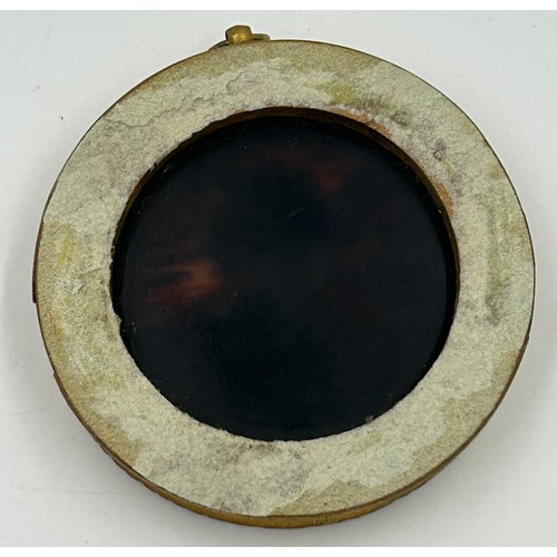 1193 - A Queen Anne tortoiseshell  Medallion mounted in a wooden gilt frame 9cm.