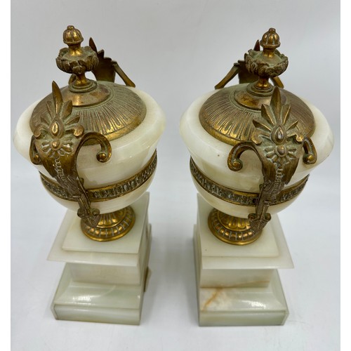 1200 - A pair of French stone garniture urns with twin handles and class plaques to the front, measuring 33... 