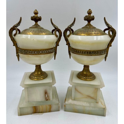 1200 - A pair of French stone garniture urns with twin handles and class plaques to the front, measuring 33... 