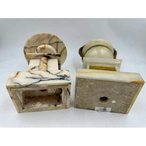 1200 - A pair of French stone garniture urns with twin handles and class plaques to the front, measuring 33... 