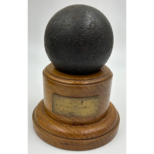 1205 - A 3.5 inch canon ball on a turned Treen plinth bearing a brass plaque inscribed 'from the Battle of ... 