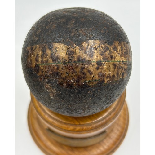 1205 - A 3.5 inch canon ball on a turned Treen plinth bearing a brass plaque inscribed 'from the Battle of ... 