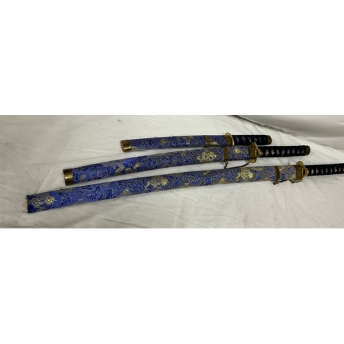 1225 - A set of three blue dragon Kitana swords decorated in blue and gold fabric (3).