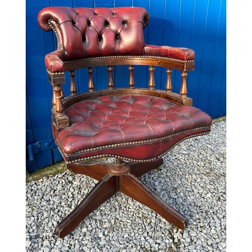 39 - A red leather upholstered swivel Captain's office chair, with padded back and arm rest on 4 supporti... 