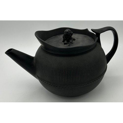 241 - A group of early 19th century black basalt wares, c. 1810. To include two teapots with lion knops, a... 