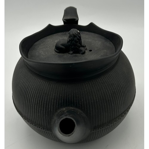 241 - A group of early 19th century black basalt wares, c. 1810. To include two teapots with lion knops, a... 