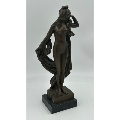 1229 - A bronze figure of a classical nude female with draped robes on a square plinth. 43cm h.