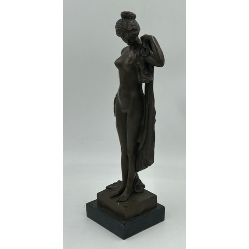 1229 - A bronze figure of a classical nude female with draped robes on a square plinth. 43cm h.