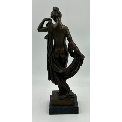 1229 - A bronze figure of a classical nude female with draped robes on a square plinth. 43cm h.