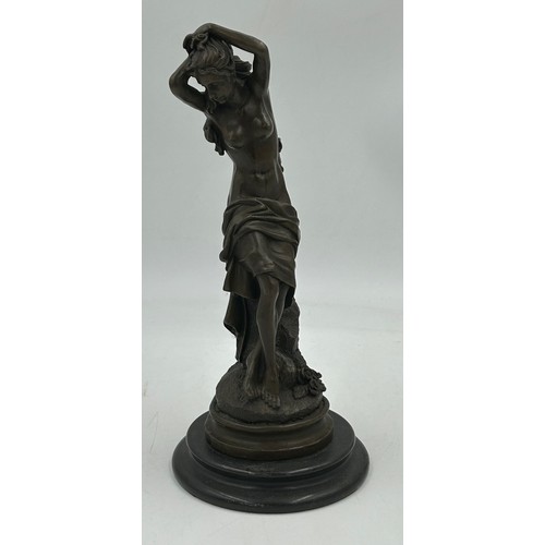 1230 - A bronze figure of a semi naked classical female on a marble base. 33cm h.