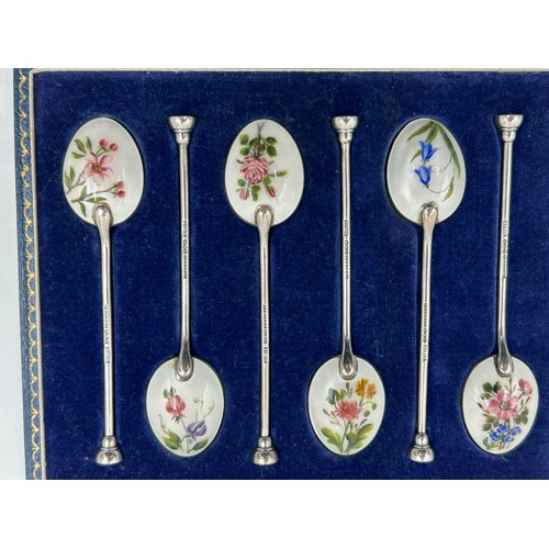 830 - A set of Six Silver and Enamel Coffee Spoons decorated with flowers in a blue case. Makers mark Henr... 