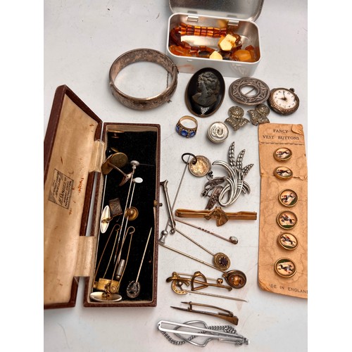 515 - A quantity of 19th and 20thC jewellery to include silver bangle, tie pins, buttons on original card,... 