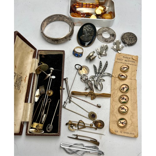 515 - A quantity of 19th and 20thC jewellery to include silver bangle, tie pins, buttons on original card,... 