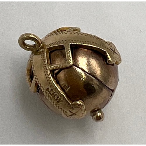 647 - A 9 carat gold and silver Masonic ball pendant opening to reveal hieroglyphics. Weight 6.9gm.