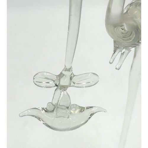 499 - A Vintage glass Stork carrying a baby in a basket. 20cm h.