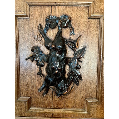 73 - An oak corner cupboard, the door with carved hare, acorns etc. 80 h x 67 w x 34cm d.