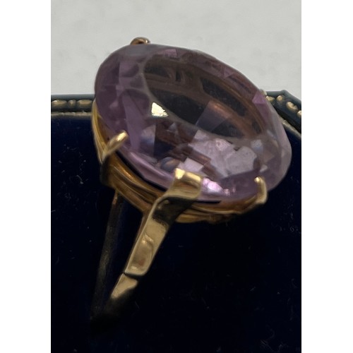 659 - A 9 carat gold ring set with large paste purple stone. Weight 10gm. Size X.