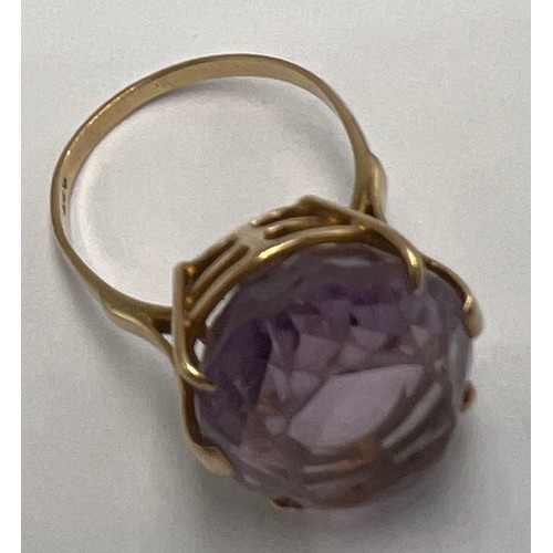 659 - A 9 carat gold ring set with large paste purple stone. Weight 10gm. Size X.