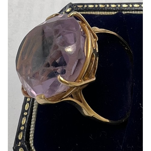 659 - A 9 carat gold ring set with large paste purple stone. Weight 10gm. Size X.