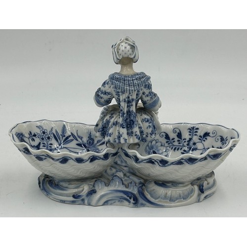 461 - A 19thC Meissen blue and white sweetmeat dish with a seated lady to the centre holding a goose and s... 