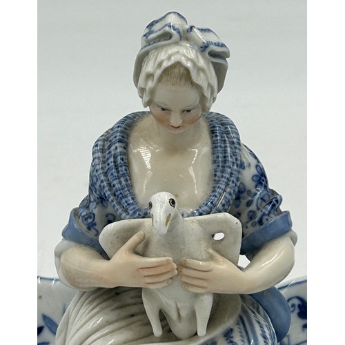 461 - A 19thC Meissen blue and white sweetmeat dish with a seated lady to the centre holding a goose and s... 