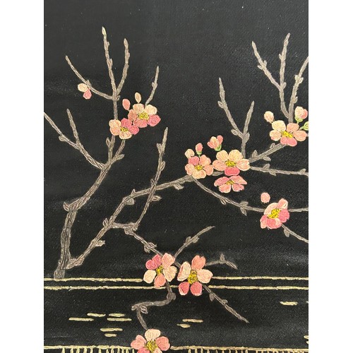 882 - A black silk panel hand stitched with a peacock and floral design, pink trim on two edges, 58cm x 58... 