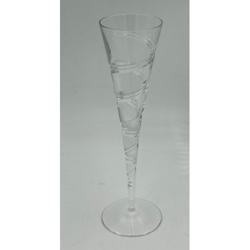 503 - A set of eight cut glass flutes with a swirl design 27.5cm h, seven fine flutes with faceted sides 2... 