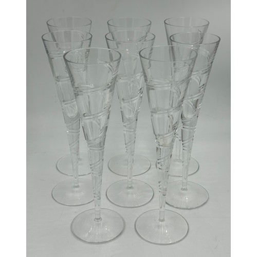 503 - A set of eight cut glass flutes with a swirl design 27.5cm h, seven fine flutes with faceted sides 2... 