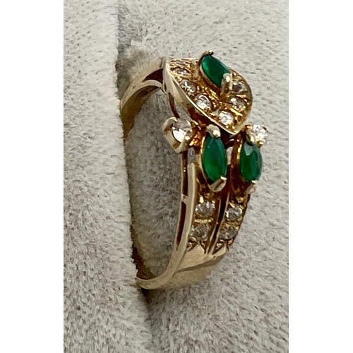 683 - A 9 carat gold ring set with clear and green stones. Size O. Weight 2.8gm.