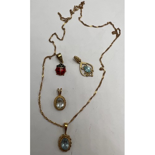 694 - Four 9 carat gold pendants, three set with pale blue stones, one with 9 carat gold chain and a ladyb... 