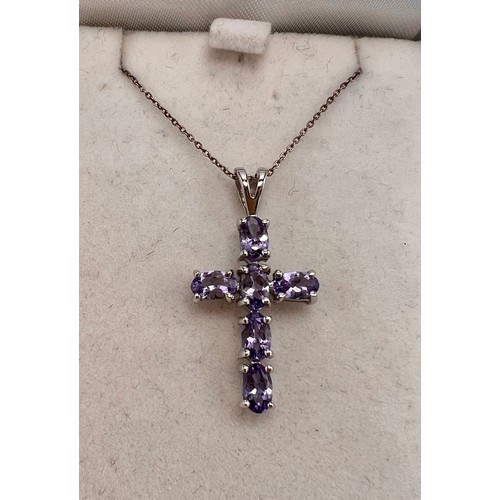 696 - A 9 carat white gold tanzanite set crucifix. Total weight 2gm.