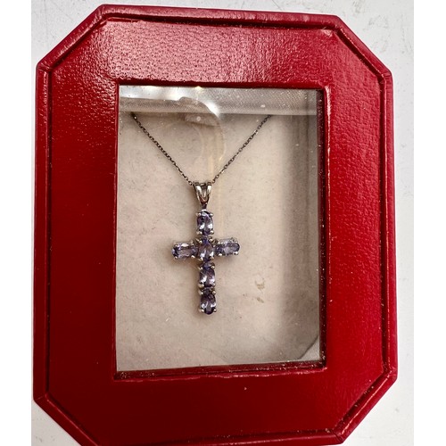 696 - A 9 carat white gold tanzanite set crucifix. Total weight 2gm.