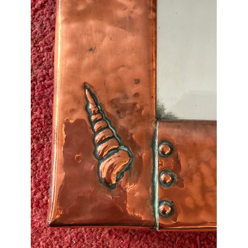 1026 - An Arts and Crafts Newlyn style hammered copper wall mirror with fish and shell design. 46 x 28cm.