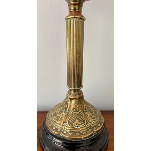 979 - A 19thC cranberry and brass oil lamp with black ceramic base. 48cm h to fitting.