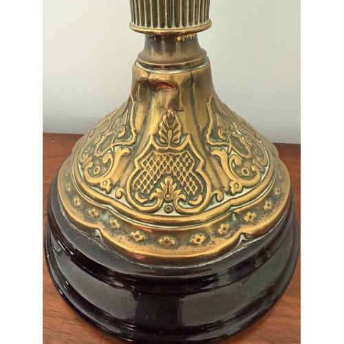 979 - A 19thC cranberry and brass oil lamp with black ceramic base. 48cm h to fitting.