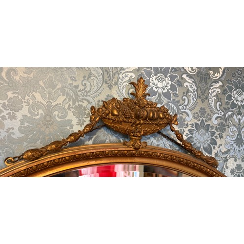 1030 - A bevel edged oval gilt framed wall mirror. 82 h x 84cm w.