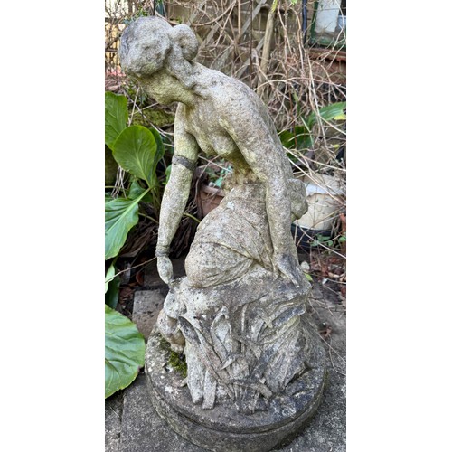 18 - A female statue in reconstituted stone. 65cm h.