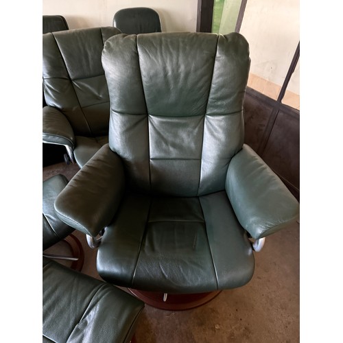 101 - Five dark green leather Stressless chairs all with footstools. One footstool opening up for storage.