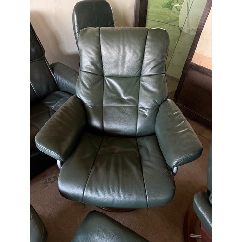 101 - Five dark green leather Stressless chairs all with footstools. One footstool opening up for storage.