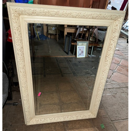 1032 - A 20thC cream framed bevel edged wall mirror. 113 h x 51cm d.