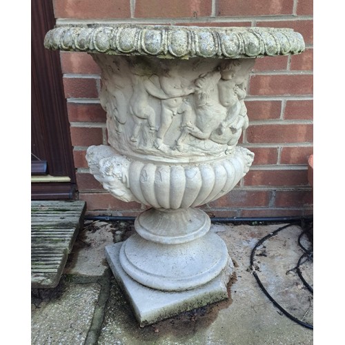 7 - A pair of reconstituted stone garden urns with putti decoration. 65 h x 54cm d.