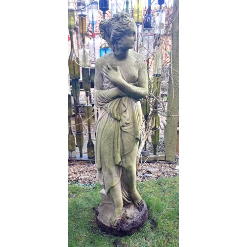 8 - A reconstituted stone statue of a scantily clad coy maiden. 126 h x 34cm at base.