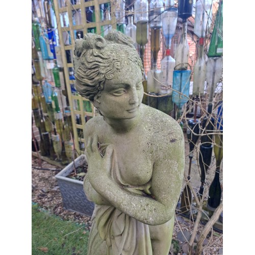 8 - A reconstituted stone statue of a scantily clad coy maiden. 126 h x 34cm at base.