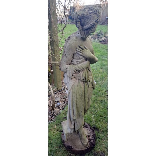 8 - A reconstituted stone statue of a scantily clad coy maiden. 126 h x 34cm at base.