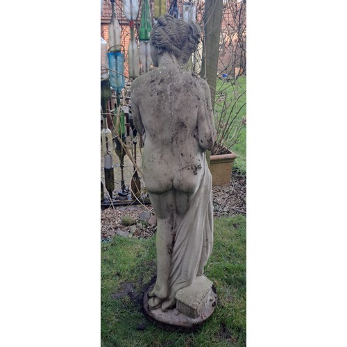 8 - A reconstituted stone statue of a scantily clad coy maiden. 126 h x 34cm at base.