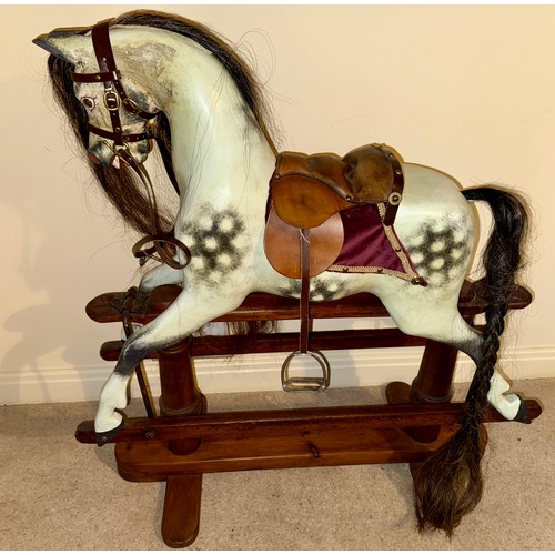 A G & J Lines rocking horse. The horse with hand painted finish and carved wood features. Hair mane, saddle and reins.